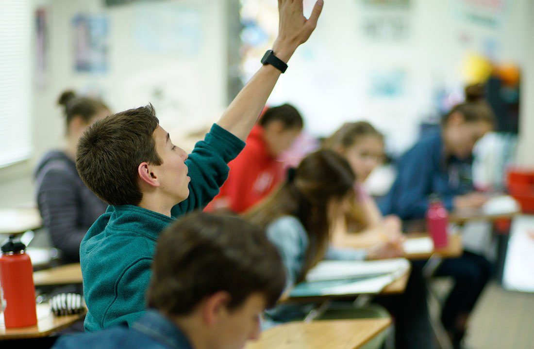 student with hand raised