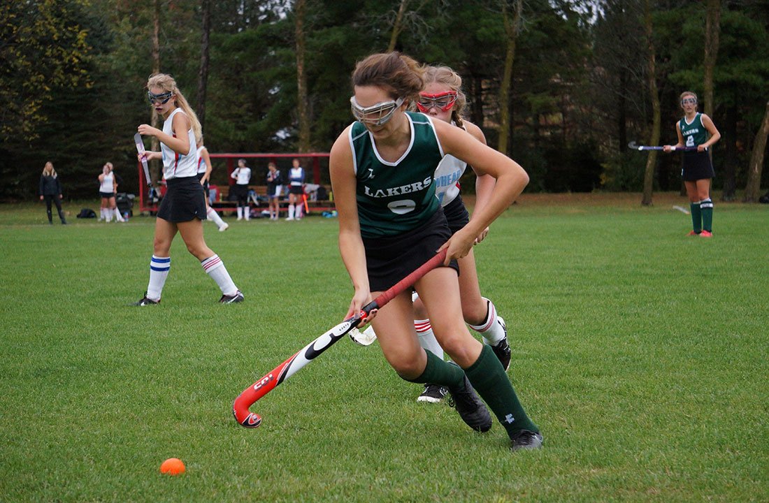 female student playing field hockey