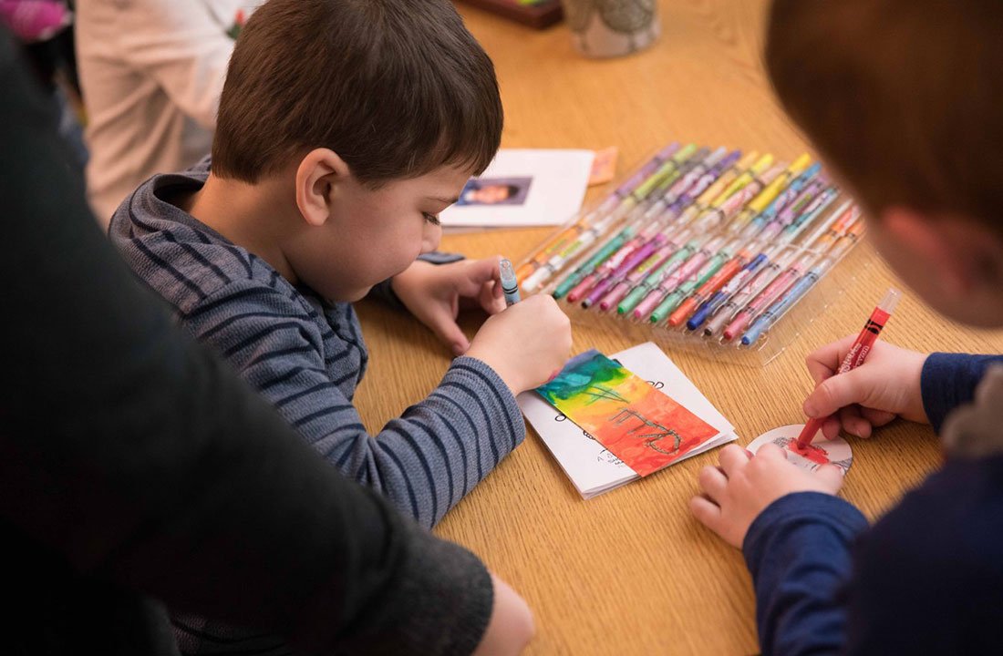 lower school students drawing with crayons