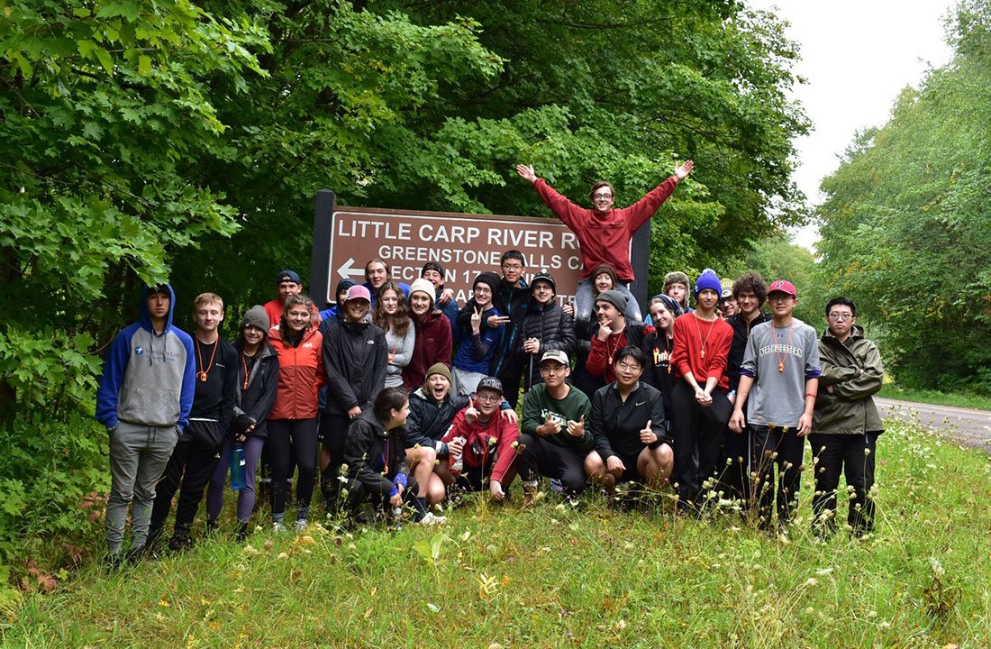 class posing in front of outdoor sign