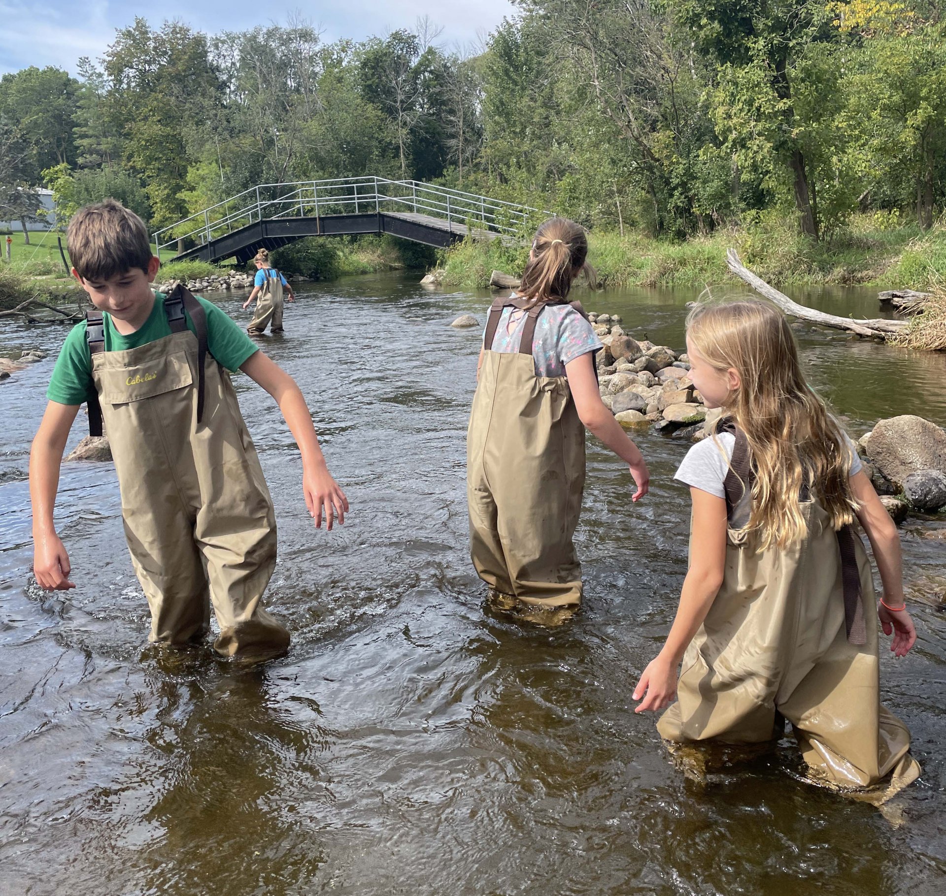 students wading through river